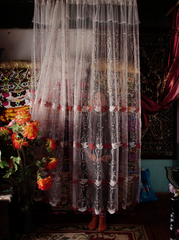 The room in which the grandmother is standing is covered by a large lace tulle, only her feet are visible
